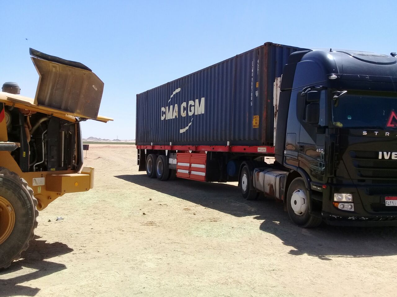 Truck and container positioned for active logistics movement and dispatch control.