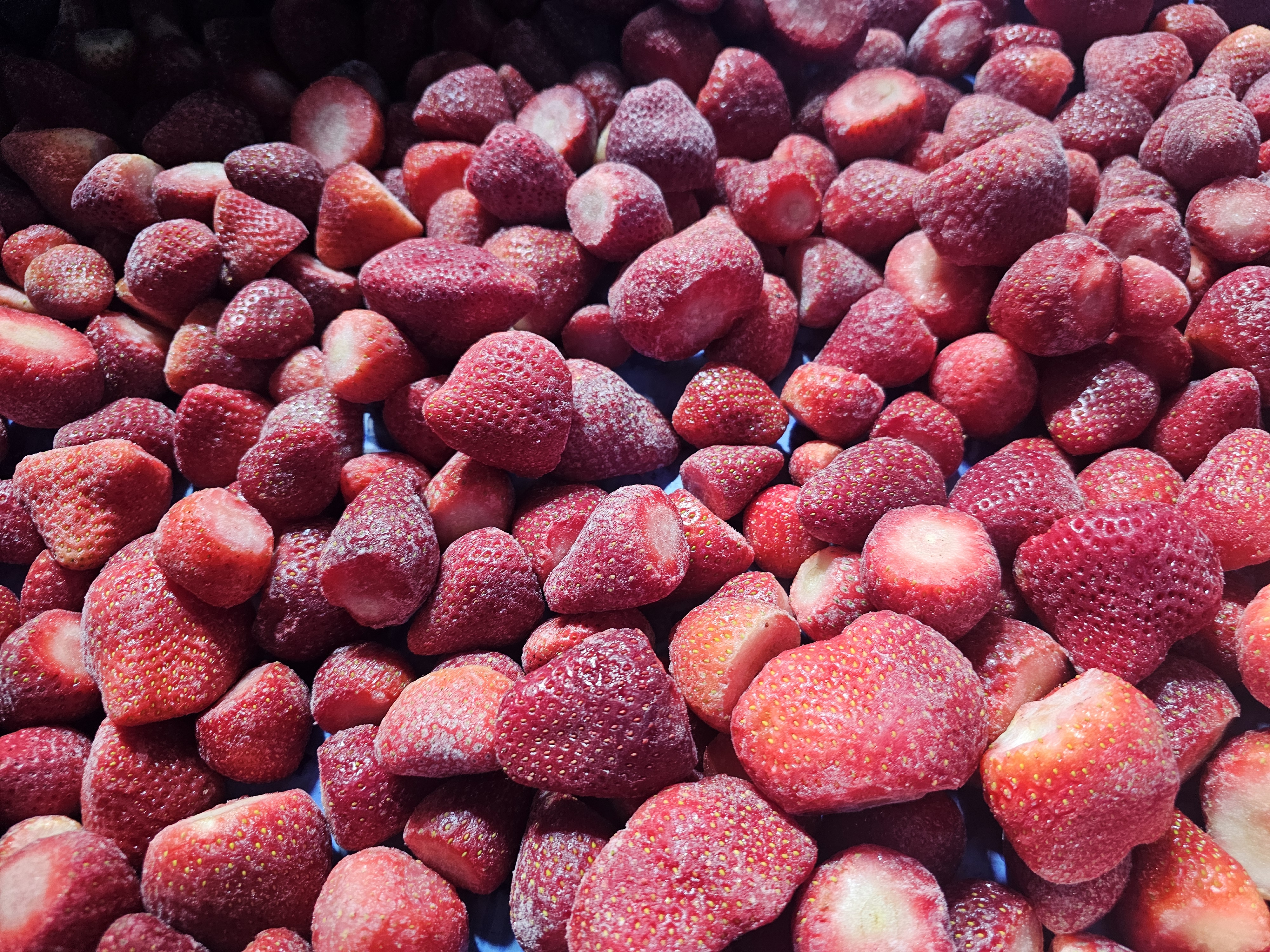 Frozen strawberries shown in bulk cold-chain product presentation.